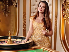 En kvindelig roulette-dealer i en guld kjole.