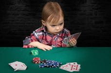 En baby spiller kort ved et casino-bord.