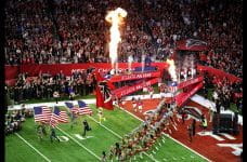 En række Atlanta Falcons NFL-spillere løber ind på deres hjemmebane, mens de bliver tiljublet af publikum.