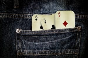 Tre spillekort i baglommen på et par jeans.