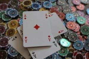Fire spillekort ovenpå en bunke af casinochips.