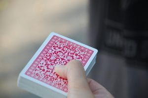 Nærbillede af en hånd, som holder en bunke spillekort med billedsiden nedad.