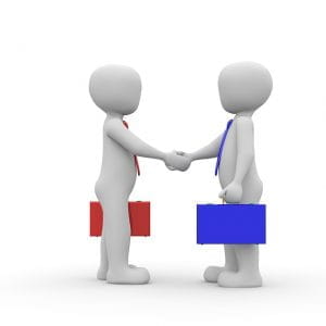 To personer giver hinanden hånden efter indgåelse af en aftale.