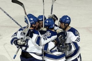 Ishockeyspillere omfavner hinanden efter scoring.