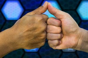 To hænder viser thumbs up mod hinanden.