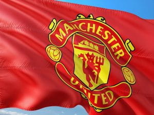 Manchester Uniteds flag vajer med blå himmel i baggrunden.