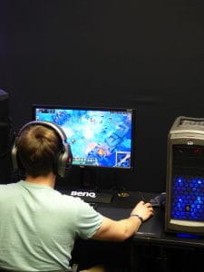 En ung mand sidder foran en computer og spiller.