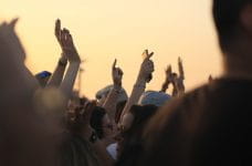 Mennesker til en koncert med hændderne i luften.