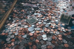 Der ligger en masse mønter – og få sedler – på gulvet.