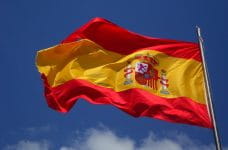 Hejst spansk flag med en blå himmel som baggrund.