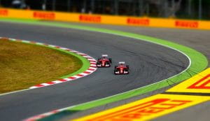 To biler der kører på en Formel 1 bane.